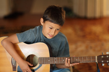 Young boy playing a guitar