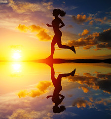 Running girl at sunset silhouette