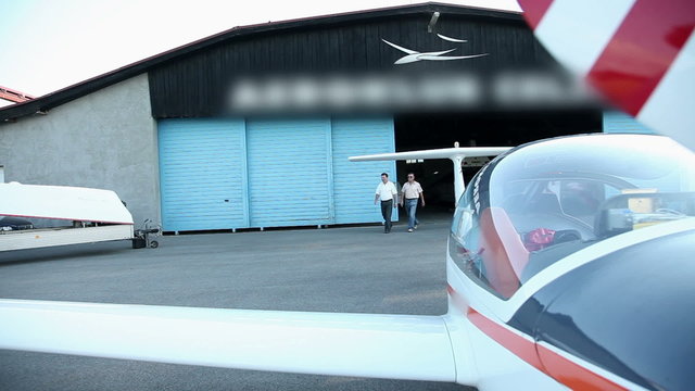 Two man coming from hangar ready for flight