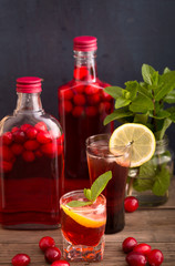 Shots and bottles of cranberry beverage