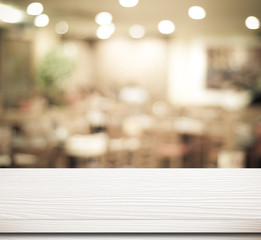 Empty white table and blurred cafe with bokeh light background