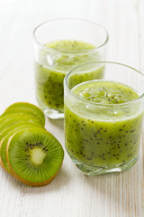 kiwi smoothie in a glass on wooden surface