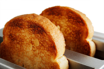 Close-up of two pieces of bread in the toaster on white