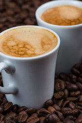 Fresh creamy expresso over roasted coffee beans background