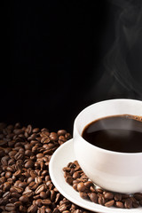 cup of steaming coffee with beans