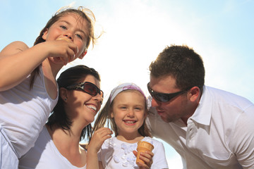 family eating ici-cream in front of ocean