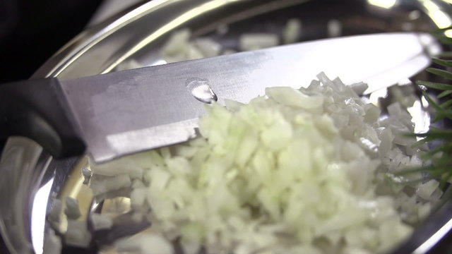 Sliced onions in the oily dish with the knife left over 