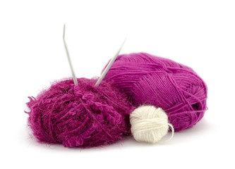 Group of pink, white woolen yarn and knitting needles 