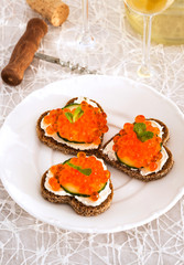 Heart shaped toasts  with red caviar and white wine