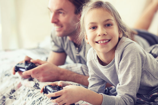 Child playing video game with father