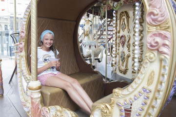 Fototapeta na wymiar Ten-year girl riding a classic French carousel.