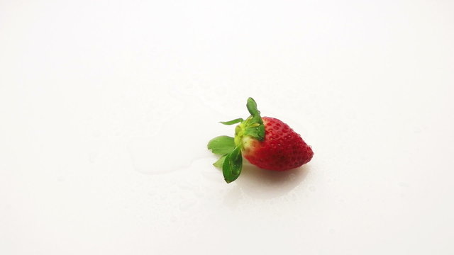strawberry falling on wet surface slow motion