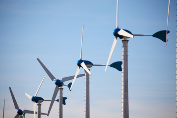 Green renewable energy concept - wind generator turbines on blue