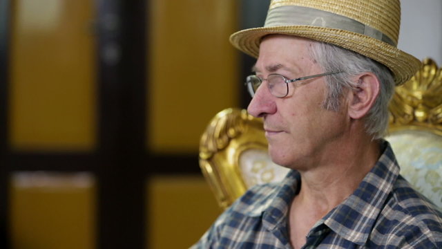 Farmer with glasses and tratched hat listening to his co-speakers