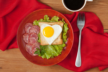 Concept of healthy breakfast or lunch - fried heart-shaped egg