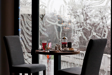 Breakfast for two in the cozy cafe on winter snowing morning. Ch