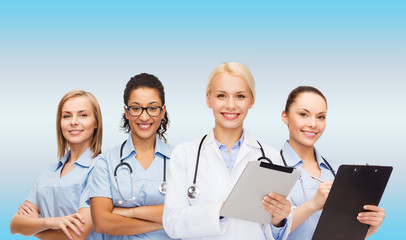smiling female doctor and nurses with tablet pc