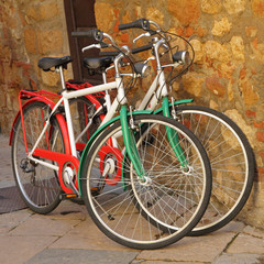 Fototapeta na wymiar two bicycles painted in colors of Italy against on stone wall o