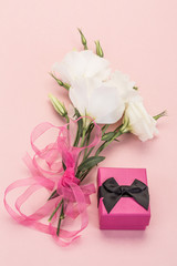white flowers and gift box on pink