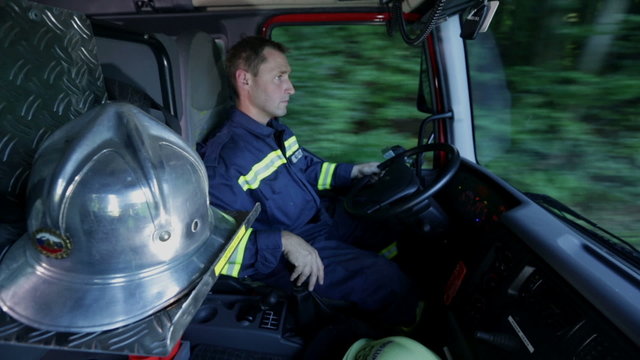 Fireman driving a firetruck shot in a cabin