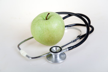 Medical stethoscope and green apple. Healty food