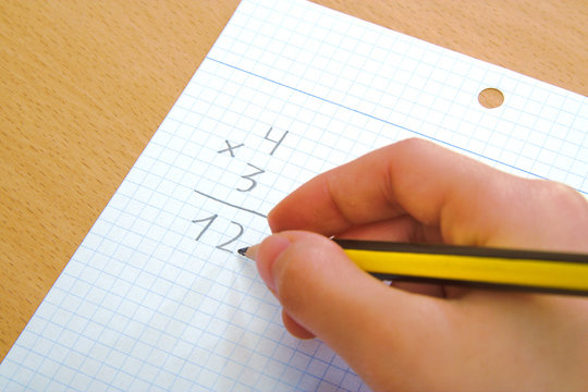 Child doing a math multiplication as homework.