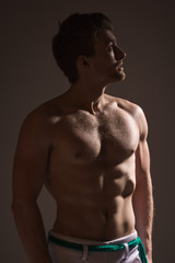 Fototapeta premium Strong athletic man on dark background