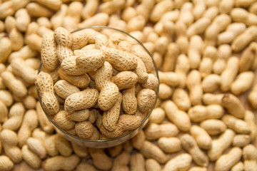 background. many peanuts in a glass cup