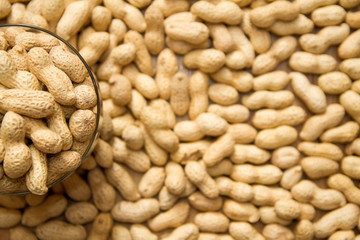 background. many peanuts in a glass cup