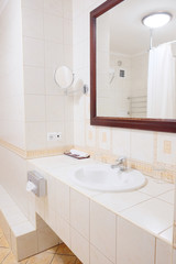 Bathroom cabinet with white sink and large mirror