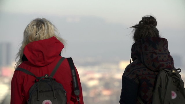 Close shot of women trying to find familiar place in great view