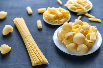 Various types of pasta on the dark background