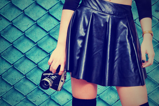 Girl with leather skirt and vintage camera