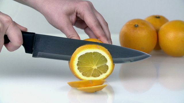 Slicing citrus to thin pieces with large knife