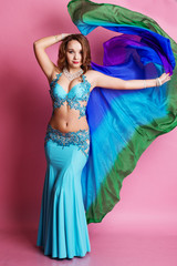 Beautiful belly dancer is wearing a blue costume