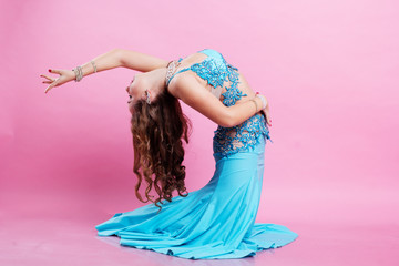 Beautiful belly dancer is wearing a blue costume