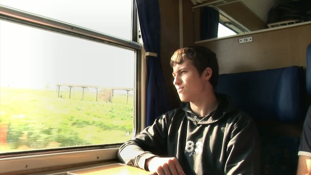 Boy stares out of the window from an old moving train