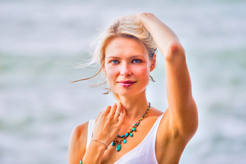 Beautiful young blonde woman posing outdoor at the rocky sea sho