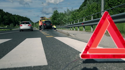 Woman in distress with broken car being helped by passer