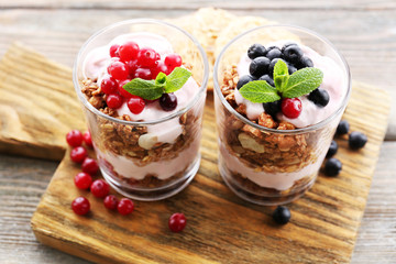 Healthy layered dessert with muesli and berries on table