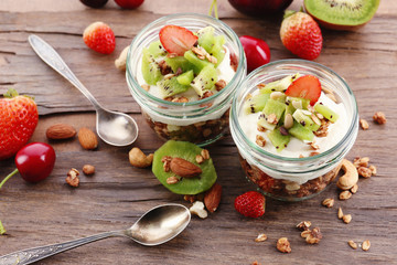 Healthy layered dessert with muesli and fruits on table