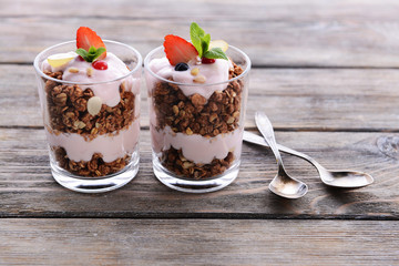 Healthy layered dessert with muesli and berries on table