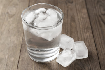 Summer cocktail with ice cubes on wooden table