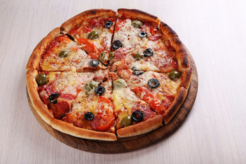 Pizza with cheese on board and color wooden table background