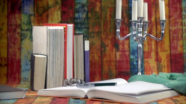 Pen falls on a big book in slow motion
