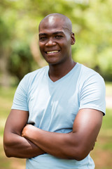 young african man with arms crossed outdoors