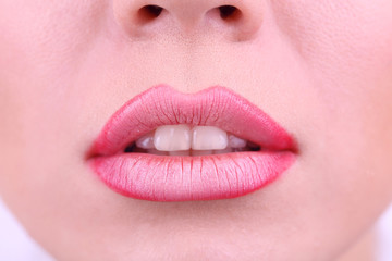 Applying lipstick on lips, on white background
