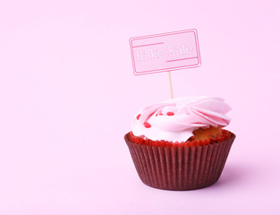 Delicious cupcake with inscription on color background
