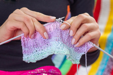 Woman knitting multicolored scarf