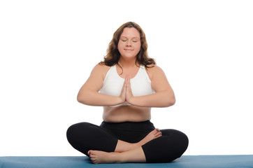 woman with overweight is meditating on mat